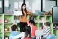 Young asian woman teacher teaching kids in kindergarten classroom, preschool education concept Royalty Free Stock Photo