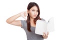 Young Asian woman thumbs down with a book Royalty Free Stock Photo