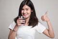 Young Asian woman thumbs up with a glass of drinking water. Royalty Free Stock Photo