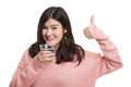 Young Asian woman thumbs up with a glass of drinking water. Royalty Free Stock Photo