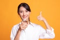 Young Asian woman thumbs up with a glass of drinking water Royalty Free Stock Photo