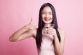 Young Asian woman thumbs up with a glass of drinking water. Royalty Free Stock Photo