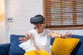 Young asian woman touching air during the VR reality experience wearing virtual reality goggles .future technology concept