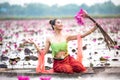 Young Asian women in Traditional dress in the boat and pink lotus flowers in the pond.Beautiful girls in traditional costume.Thai