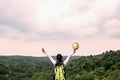 young asian woman traveler with backpack relaxing on mountian and looking forest