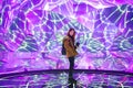 Young asian woman traveler posing on the stage with neon colored lights.