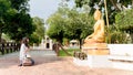 Young Asian woman traveler wearing white shirt and hat praying Buddha statue Royalty Free Stock Photo