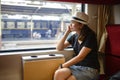 Young asian woman traveling looking out the window while sitting in the train