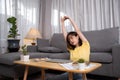 Young asian woman tried to lying stretching after working with laptop computer on couch Royalty Free Stock Photo