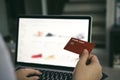 Young asian woman typing laptop keyboard and holding credit card at home with online shopping or internet banking concept Royalty Free Stock Photo