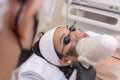 A young asian woman undergoes a laser carbon peel procedure at a skin or dermatologist clinic