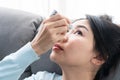 Young Asian woman uses eye drops for eye treatment. Redness, dry eyes, allergy and eye itching. Vision and ophthalmology medicine