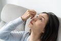 Young Asian woman uses eye drops for eye treatment. Redness, dry eyes, allergy and eye itching. Vision and ophthalmology medicine