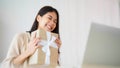 Young asian woman using computer laptop at home. Female showing gift box while on video conversation with friend Royalty Free Stock Photo