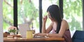 Young Asian woman is using a computer laptop while sitting at the wooden working desk Royalty Free Stock Photo