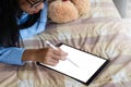 Young asian woman using digital tablet computer pc on the bed. Royalty Free Stock Photo