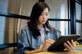 Young asian woman using digital tablet at home office background, casual office life, Asian female and digital tablet while Royalty Free Stock Photo