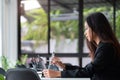 Young asian woman using digital tablet with pen stylus while sitting at her office desk in modern office Royalty Free Stock Photo