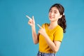 Young asian woman using finger to pointing on blue baclground Royalty Free Stock Photo