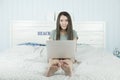 Young asian woman using laptop computer in bedroom. Royalty Free Stock Photo