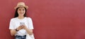 Young asian woman using phone with smiling, happy and relax emotion, over red background with copy space, Happy asia girl on phone Royalty Free Stock Photo