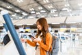 Young Asian woman using self check-in kiosks in airport terminal Royalty Free Stock Photo