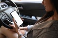 Young Asian woman using smartphone with blank screen while driving car. Royalty Free Stock Photo