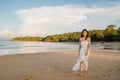 Young Asian woman walking on beach. Beautiful female happy relax walking on beach near sea when sunset in evening. Lifestyle women Royalty Free Stock Photo