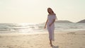 Young Asian woman walking on beach. Beautiful female happy relax walking on beach near sea when sunset in evening. Lifestyle women Royalty Free Stock Photo