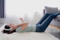 Young Asian woman was listening to the song and she happily sang in the room. With her sleeping on the carpet Royalty Free Stock Photo