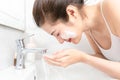 Young Asian woman washing her face in bathroom Royalty Free Stock Photo