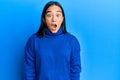 Young asian woman wearing casual winter sweater afraid and shocked with surprise and amazed expression, fear and excited face Royalty Free Stock Photo