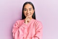 Young asian woman wearing casual winter sweater smiling looking confident at the camera with crossed arms and hand on chin Royalty Free Stock Photo