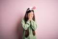 Young asian woman wearing cute easter bunny ears over pink background with sad expression covering face with hands while crying Royalty Free Stock Photo