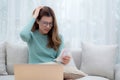 Young asian woman wearing glasses sitting on sofa worried with bills about financial and stress at home. Royalty Free Stock Photo