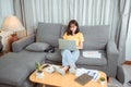 Young asian woman wearing headphones having video chat with friends using laptop camera while siting Royalty Free Stock Photo