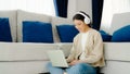 Young asian woman wearing headset in good spirits working on laptop at home Royalty Free Stock Photo