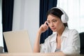 Young asian woman wearing headset working on computer laptop at house Royalty Free Stock Photo
