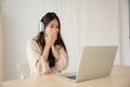 Young asian woman wearing headset while working on computer laptop at house Royalty Free Stock Photo