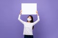 Asian woman wearing medical mask holding white paper board with empty space for text overhead Royalty Free Stock Photo