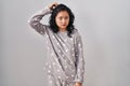 Young asian woman wearing pajama confuse and wonder about question Royalty Free Stock Photo