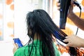 Young asian woman wearing protection mask and using smartphone while she getting a drying hair with hair dryer by hairdresser. Royalty Free Stock Photo