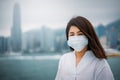 Young asian woman wearing protective face mask in city due to the polluted air or pm 2.5 and Coronavirus disease or COVID-19