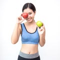 Young asian woman wearing sportwear holding red and green apple