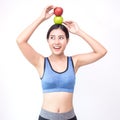 Young asian woman wearing sportwear holding red and green apple