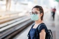 Young Asian woman wearing Surgical face mask against Novel coronavirus or Corona Virus Disease Covid-19 at public train station Royalty Free Stock Photo