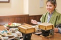 Young Asian woman wearing Yukata with Japanese Dinner set and appetizer on wooden table in Traditional ryokan resort at Royalty Free Stock Photo