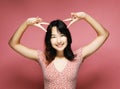 young asian woman wears pink dress showing victory sign Royalty Free Stock Photo