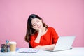 Young Asian woman in a white shirt. She was lying at her desk with a pink background isolated Royalty Free Stock Photo