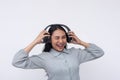 A young asian woman winks while listening to great music on her wireless headphones.  on a white background Royalty Free Stock Photo